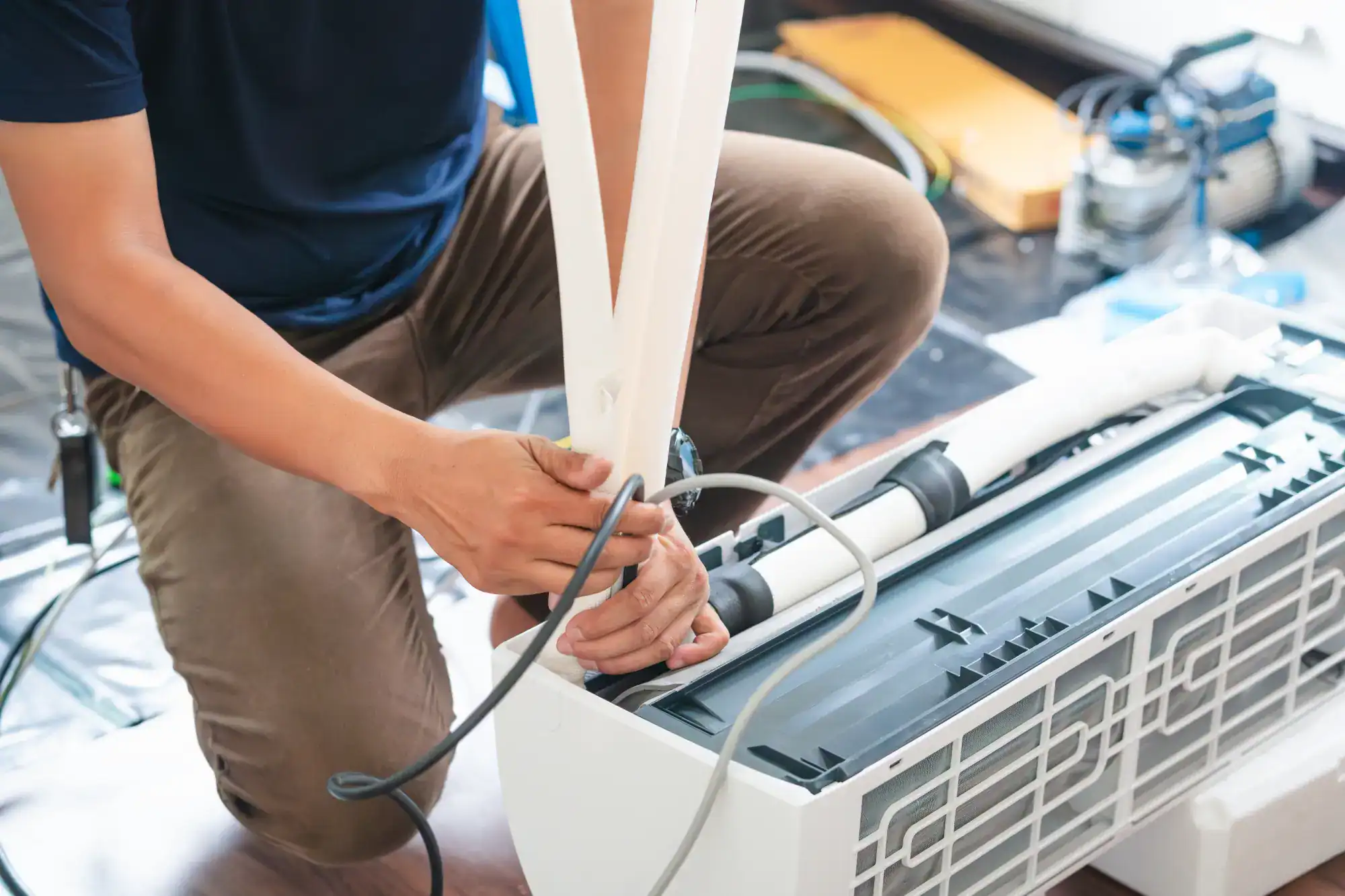 A man is fixing an air conditioner.